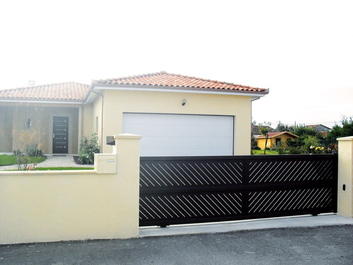 Installation d'un portail noir coulissant sur mesure, ajourée.